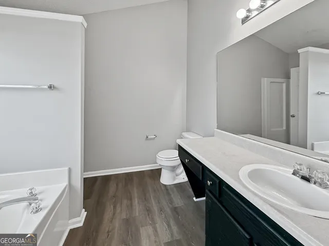a bathroom with a granite countertop sink a toilet and vanity
