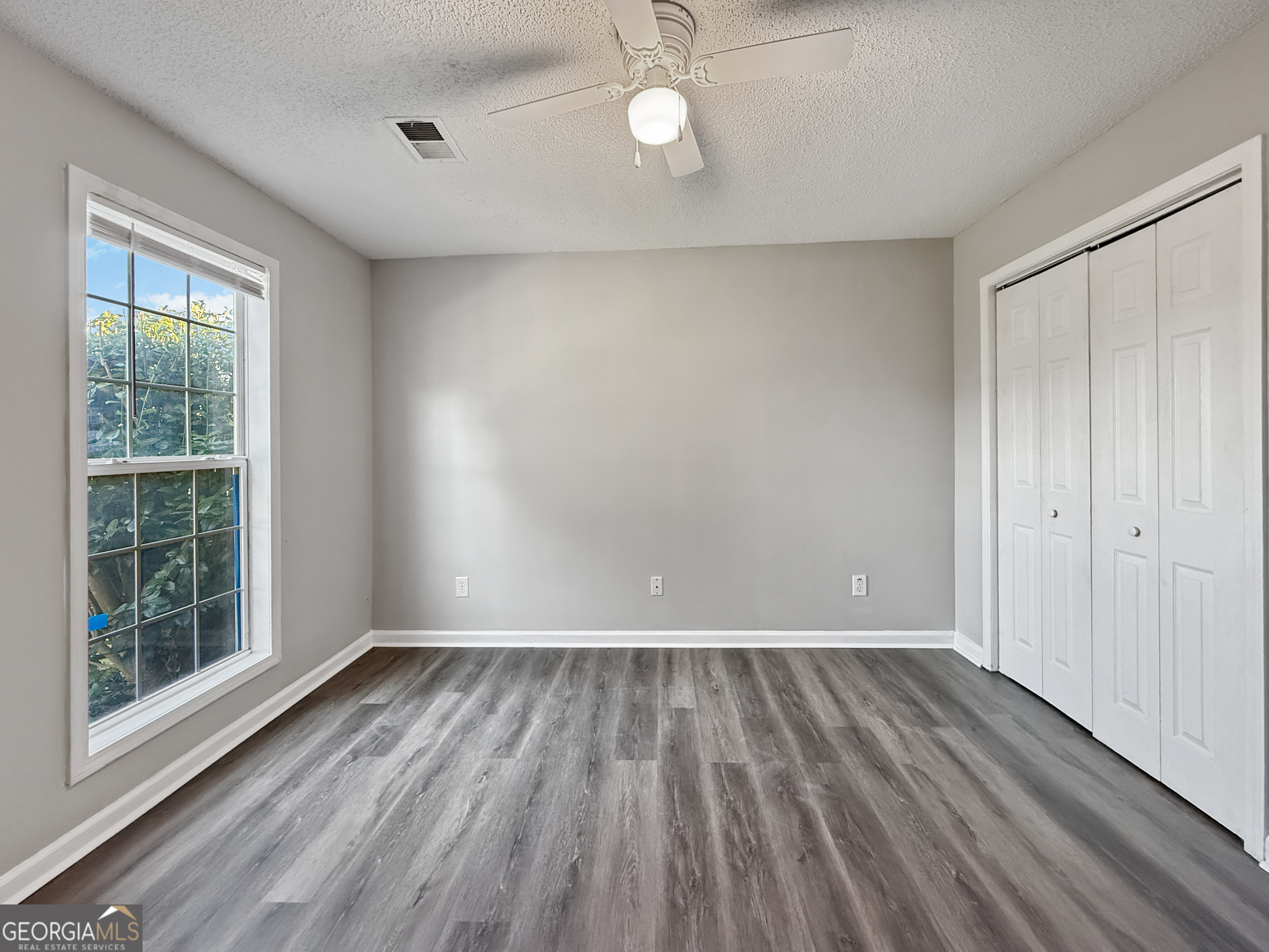 231 Ferguson Avenue Locust Grove, GA 30248 - Photo 15 of 26 a view of an empty room with wooden floor and a window