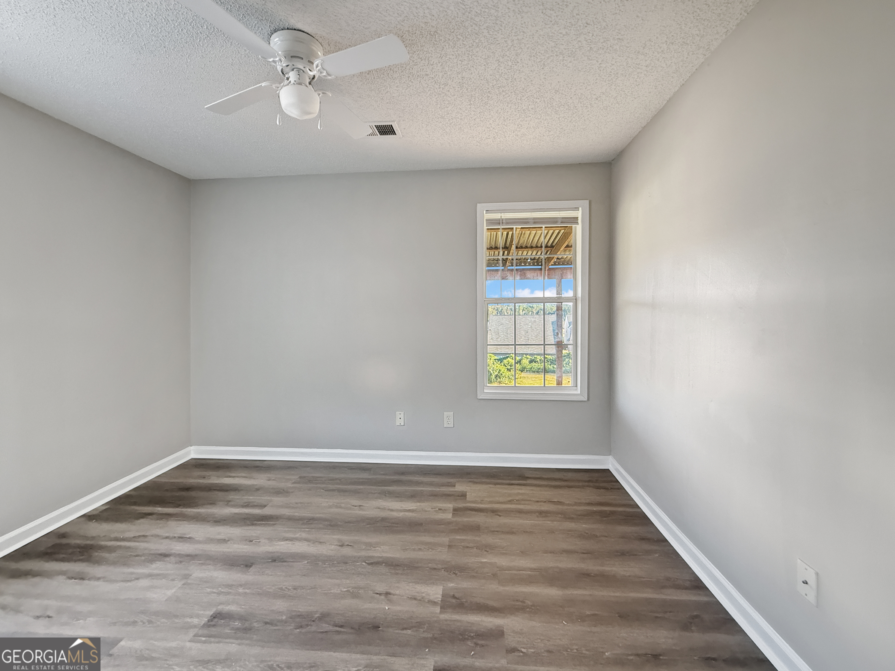 231 Ferguson Avenue Locust Grove, GA 30248 - Photo 17 of 26 wooden floor in an empty room with a window