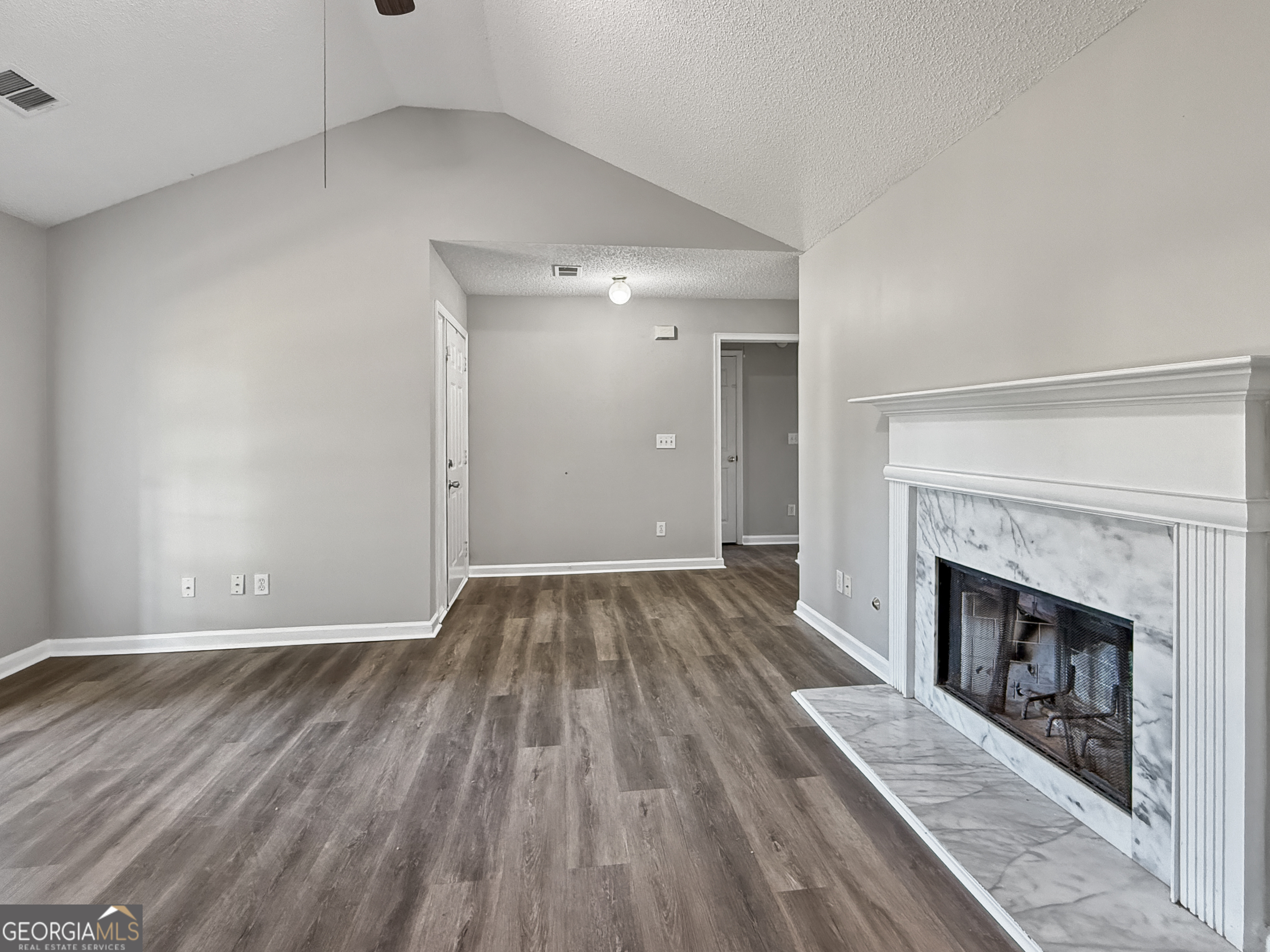 231 Ferguson Avenue Locust Grove, GA 30248 - Photo 6 of 26 a view of an empty room with wooden floor fireplace and a window