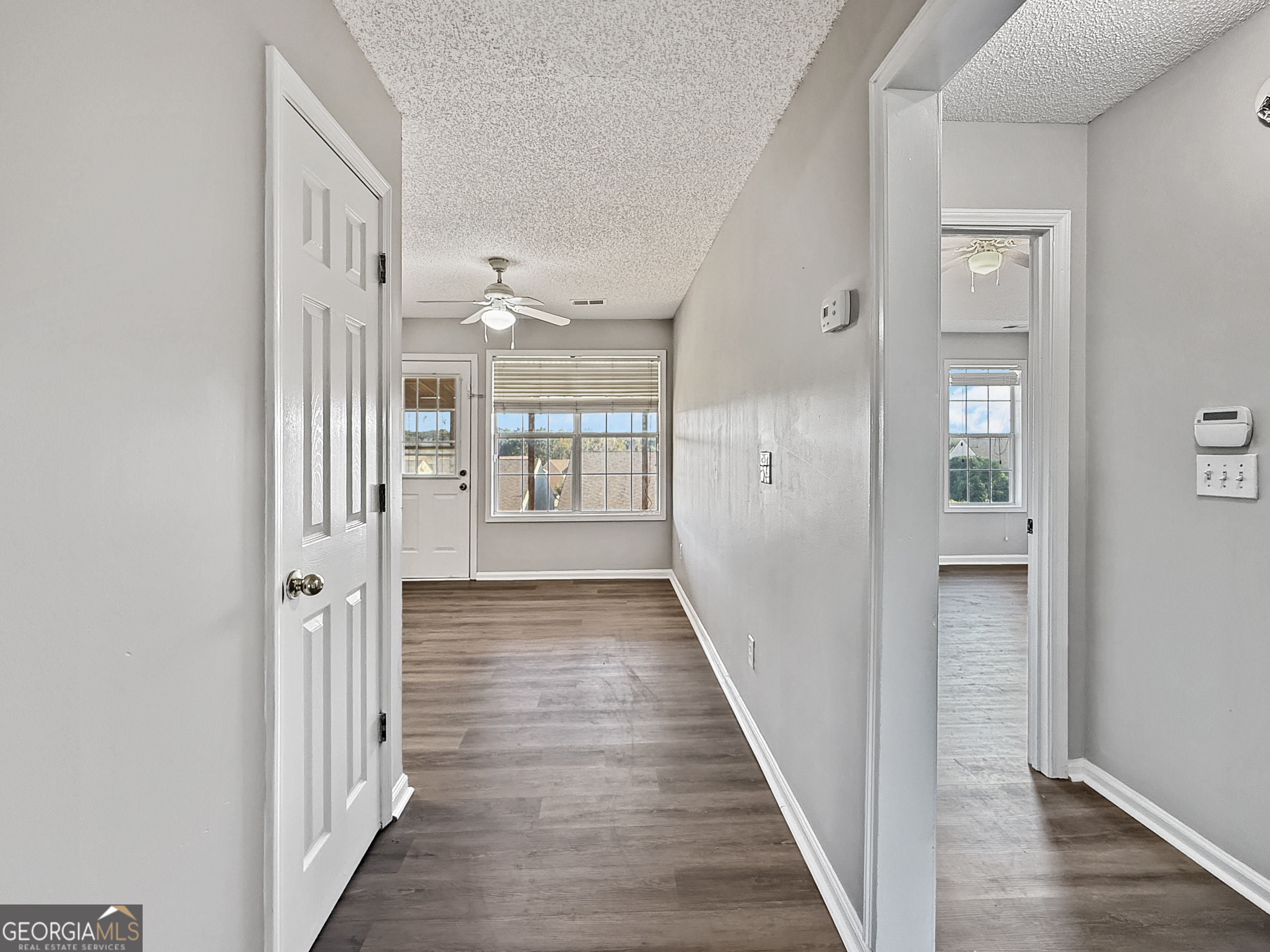 231 Ferguson Avenue Locust Grove, GA 30248 - Photo 7 of 26 a view of a hallway with wooden floor and a bathroom