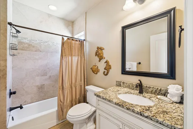 a bathroom with a granite countertop sink toilet mirror and shower