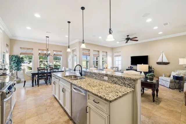 a very nice looking kitchen with a large center island and living room view