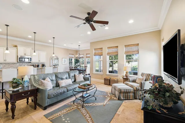 a living room with furniture kitchen view and a large window