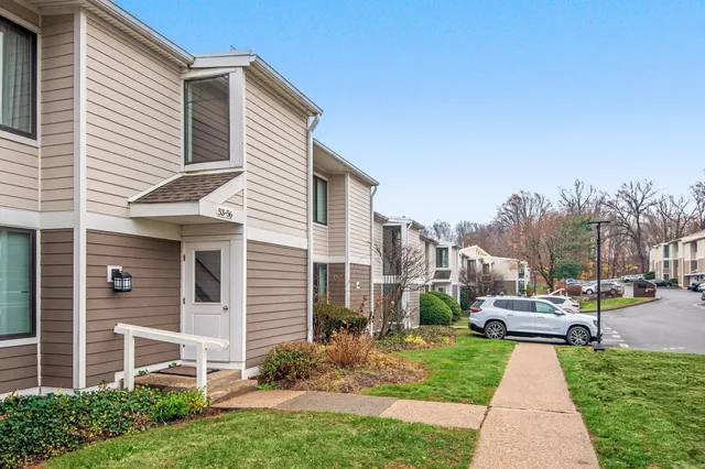 a front view of a house with garden and lake view