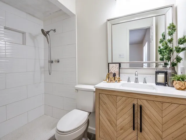 a bathroom with a toilet sink vanity and mirror