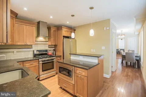 a kitchen with stainless steel appliances granite countertop a stove a sink and a refrigerator