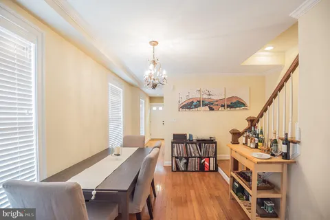 a view of a dining room with furniture a chandelier and windows