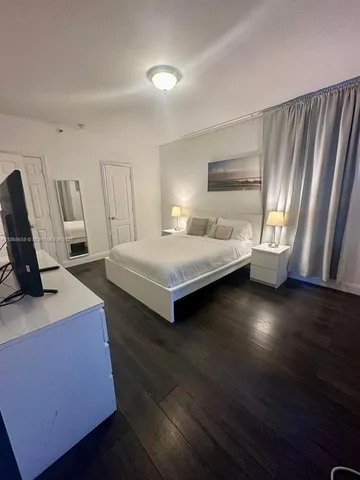 a bedroom with a bed and a television