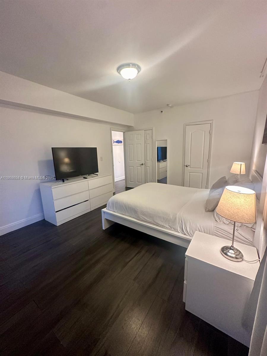 3030 Collins Avenue, Unit 4F Miami Beach, FL 33140 - Photo 14 of 24 a bedroom with a bed and a television