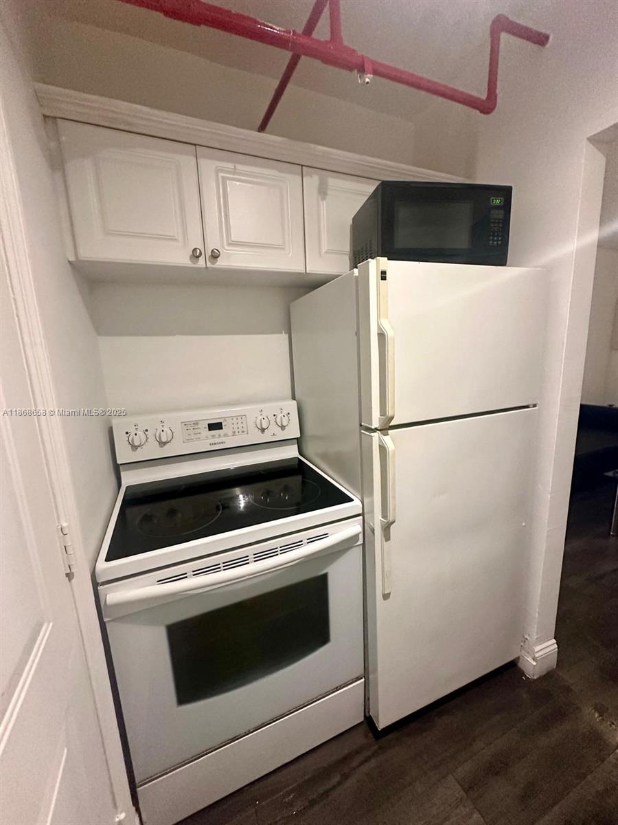 3030 Collins Avenue, Unit 4F Miami Beach, FL 33140 - Photo 15 of 24 a kitchen with a stove top oven and refrigerator