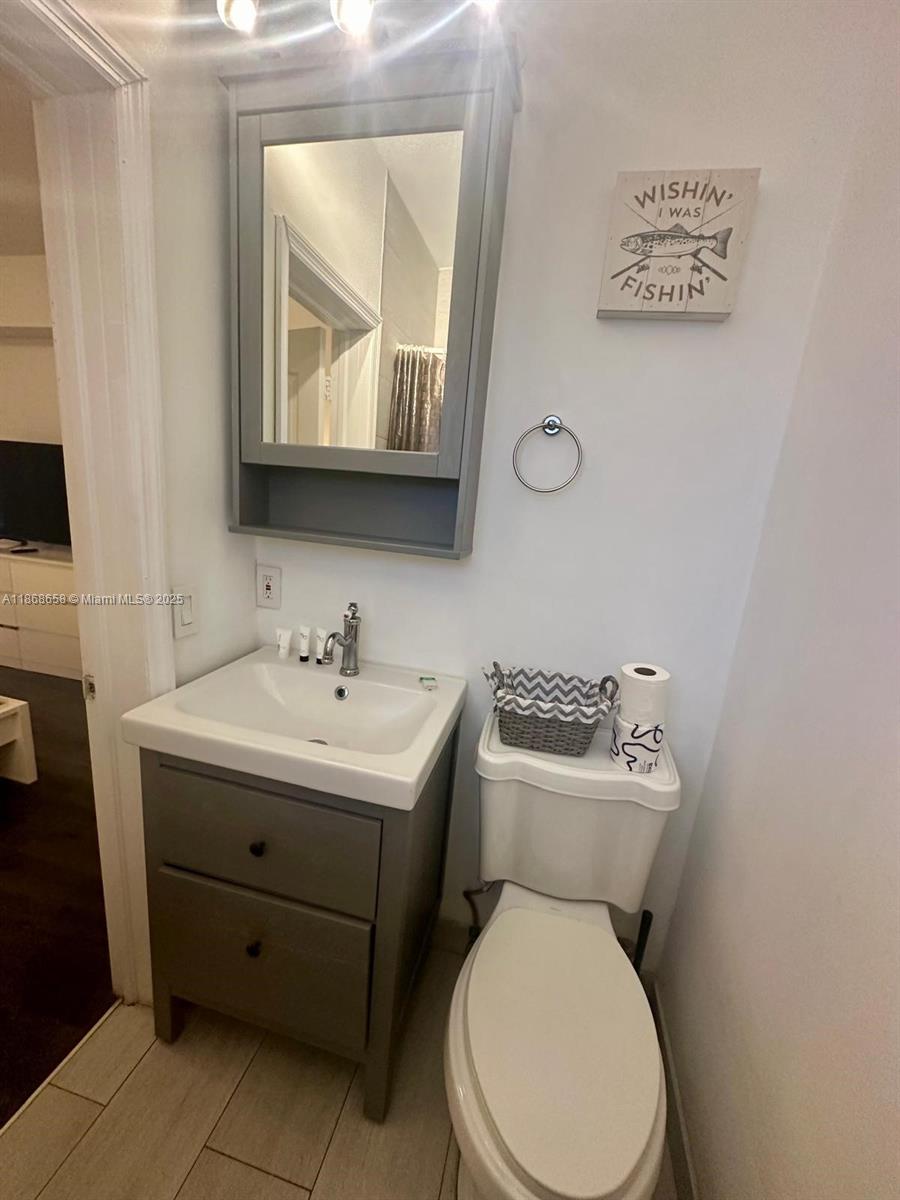 3030 Collins Avenue, Unit 4F Miami Beach, FL 33140 - Photo 16 of 24 a bathroom with a toilet sink and mirror
