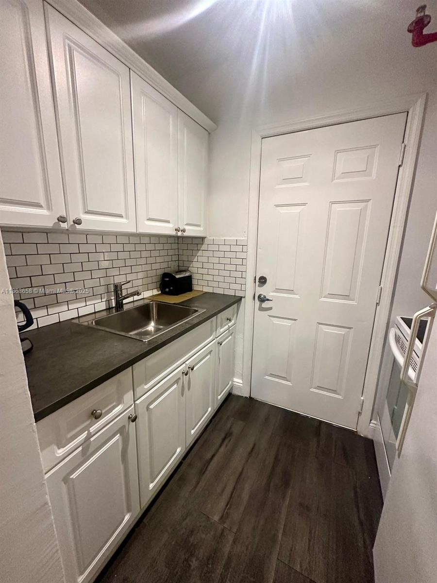 3030 Collins Avenue, Unit 4F Miami Beach, FL 33140 - Photo 18 of 24 a kitchen with granite countertop white cabinets and white appliances