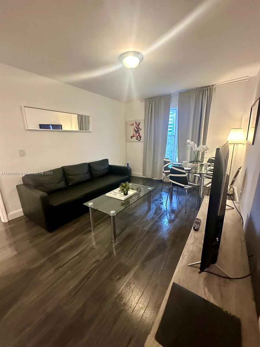 3030 Collins Avenue, Unit 4F Miami Beach, FL 33140 - Photo 19 of 24 a living room with furniture and a flat screen tv