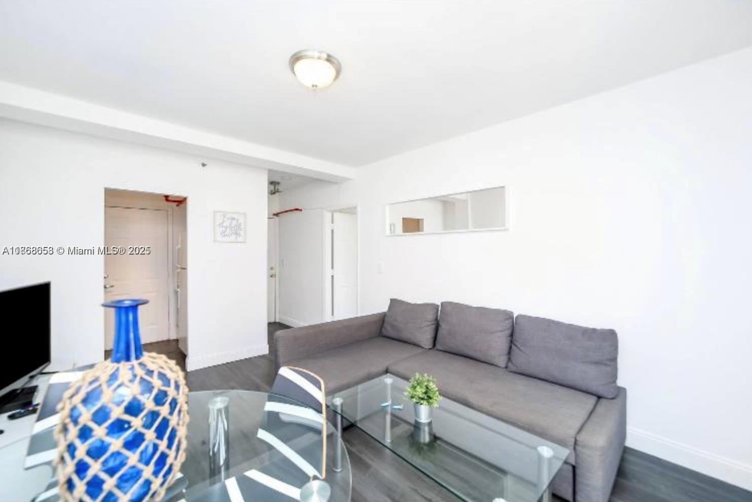 3030 Collins Avenue, Unit 4F Miami Beach, FL 33140 - Photo 2 of 24 a living room with furniture and a flat screen tv