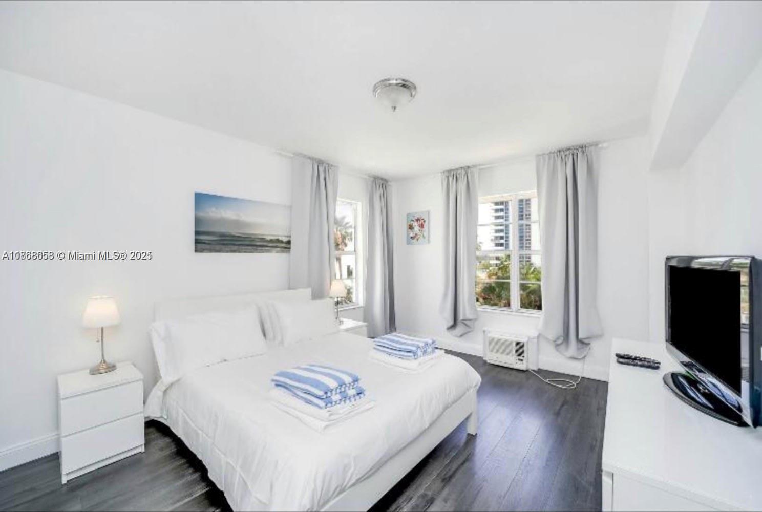 3030 Collins Avenue, Unit 4F Miami Beach, FL 33140 - Photo 5 of 24 a spacious bedroom with a bed and a flat screen tv