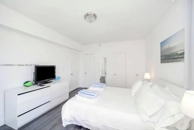 a bedroom with a flat screen tv and a bed