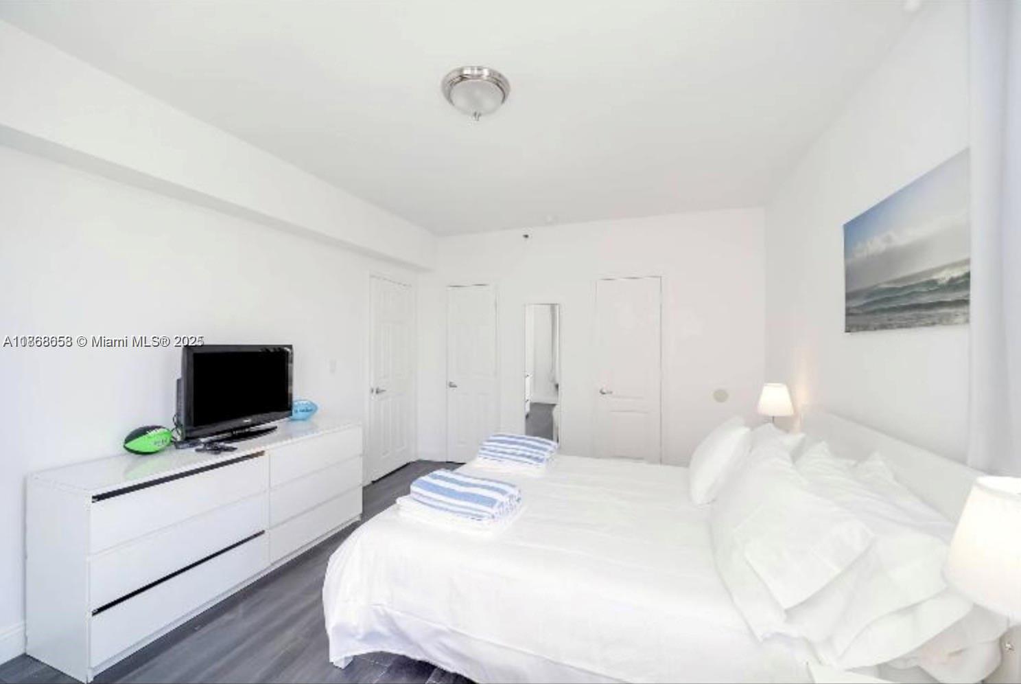 3030 Collins Avenue, Unit 4F Miami Beach, FL 33140 - Photo 6 of 24 a bedroom with a flat screen tv and a bed