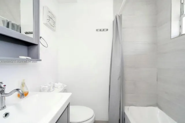 a bathroom with a sink a toilet and shower curtain