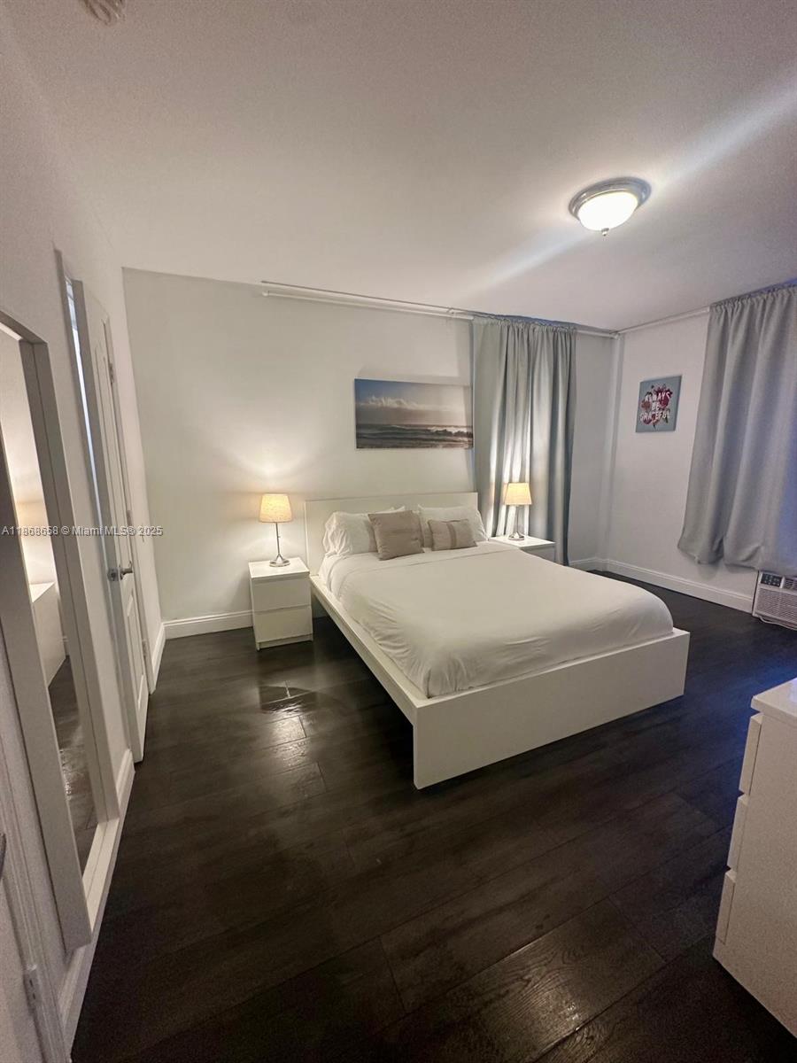 3030 Collins Avenue, Unit 4F Miami Beach, FL 33140 - Photo 10 of 24 a bedroom with a bed and wooden floor