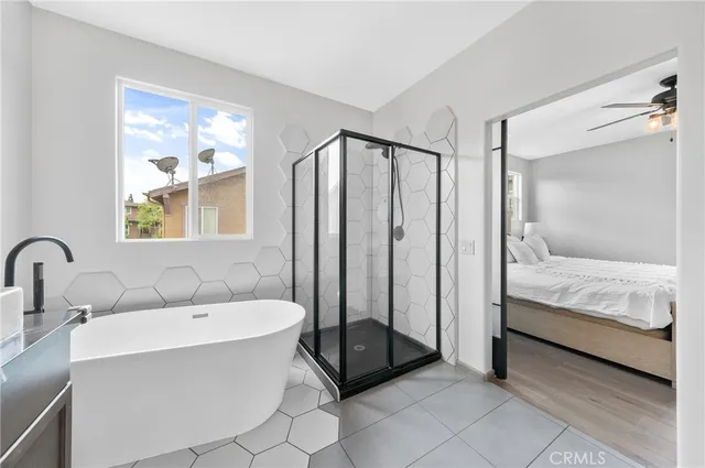 a en suite bathroom with a double vanity sink a mirror and a bathtub