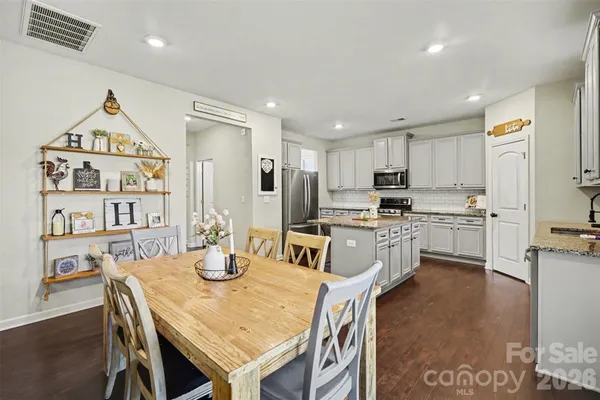 a kitchen with kitchen island a stove a table and chairs