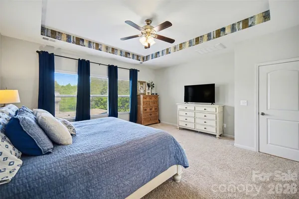 a spacious bedroom with a bed and a flat screen tv