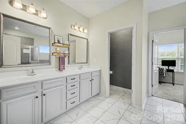 a spacious bathroom with a granite countertop sink and a mirror