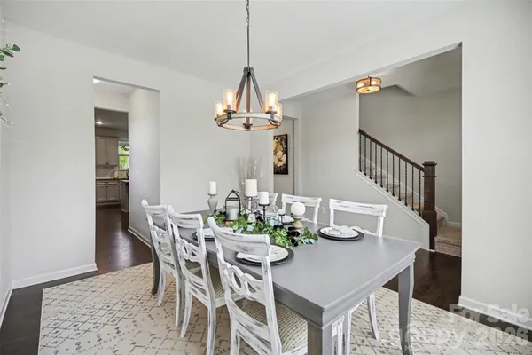 a dining room with furniture a chandelier and wooden floor