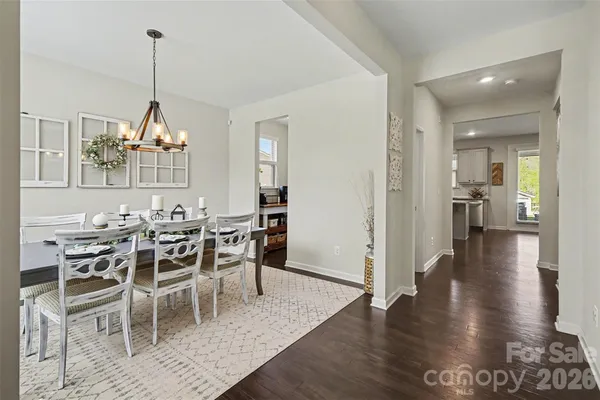 a dining room with furniture a chandelier and wooden floor