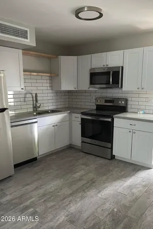 a kitchen with stainless steel appliances granite countertop a sink a stove a microwave and cabinets