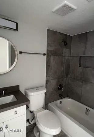 a white toilet sitting next to a bathroom sink and tub