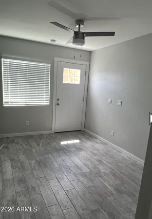 en empty room with windows and ceiling fan