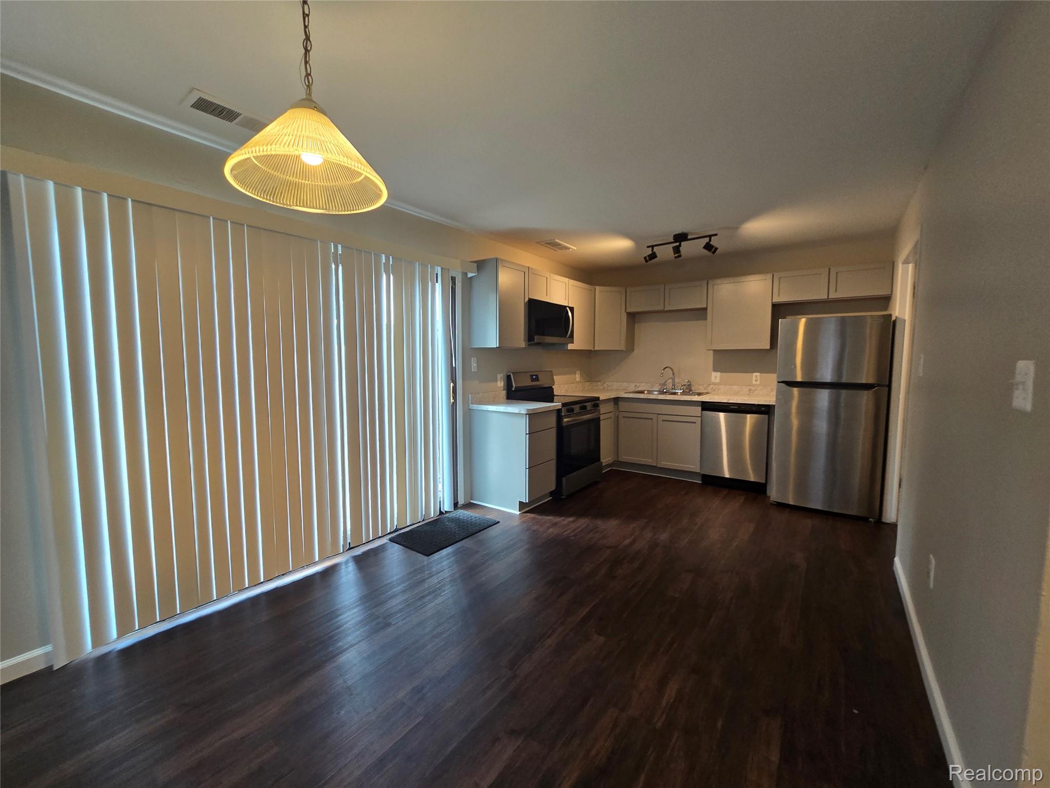 23568 Lahser Road Southfield, MI 48033 - Photo 4 of 18 Wood-finish flooring, stainless steel appliances, track lighting, and a suspended pendant light