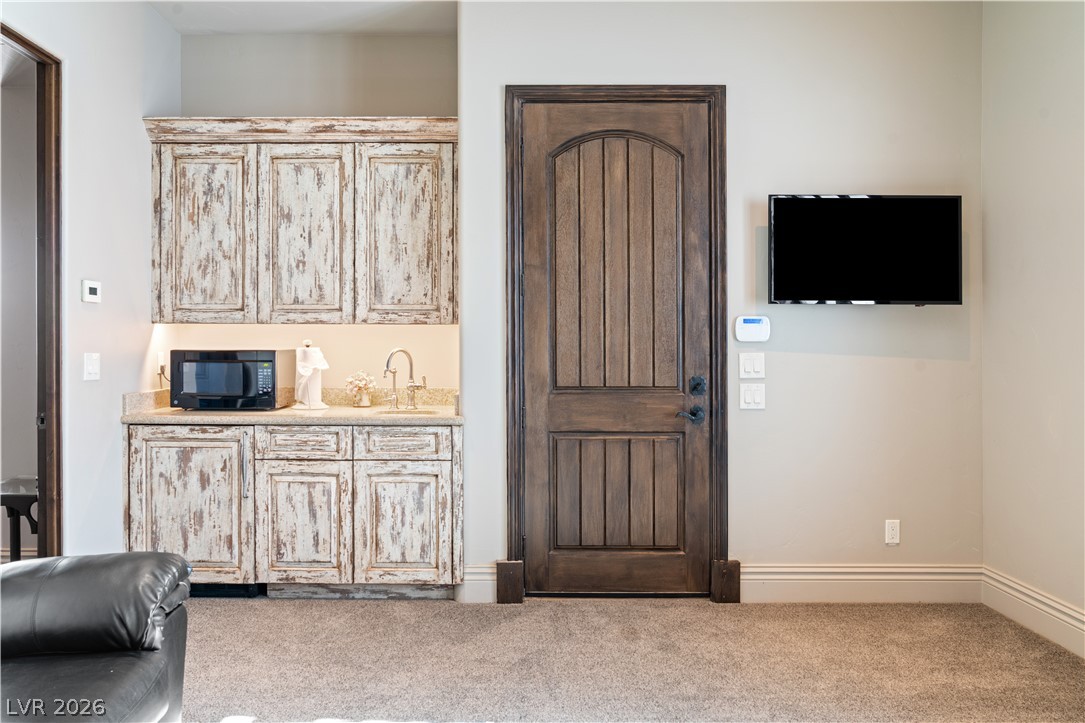 1123 Christian Road Henderson, NV 89002 - Photo 44 of 94 A wet bar with distressed cabinetry and a microwave offers convenient entertaining and refreshment.