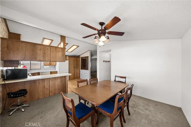 a view of a dining room with furniture and a chandelier fan