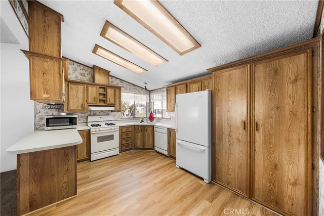 a kitchen with stainless steel appliances granite countertop a refrigerator a stove top oven a sink and dishwasher
