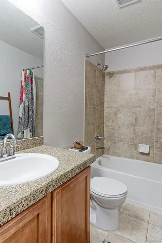 a bathroom with a granite countertop sink toilet and shower