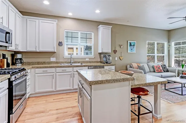a kitchen with stainless steel appliances granite countertop a sink stove and cabinets
