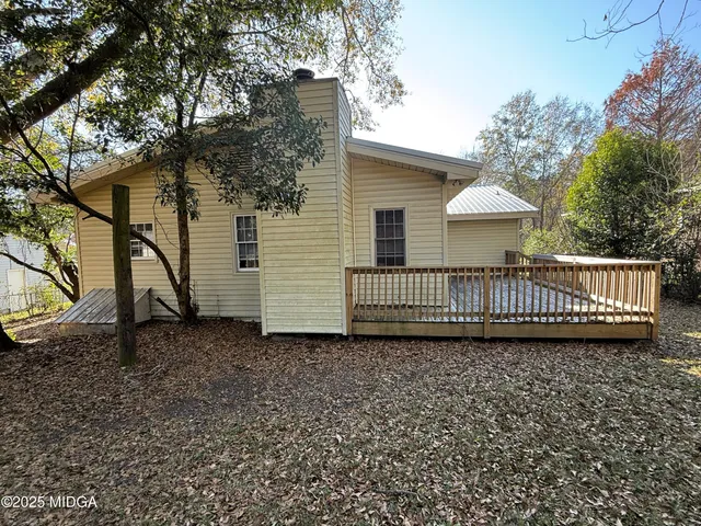 a view of a house with a patio and a yard