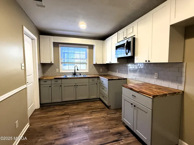 a kitchen with stainless steel appliances granite countertop a stove a sink and a microwave