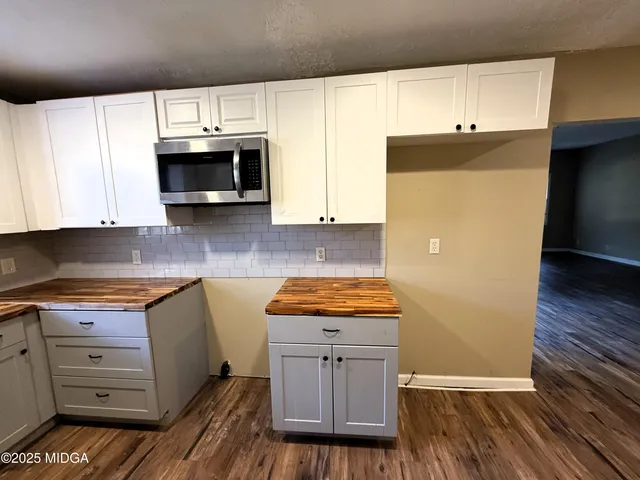 a kitchen with granite countertop wooden cabinets and white appliances