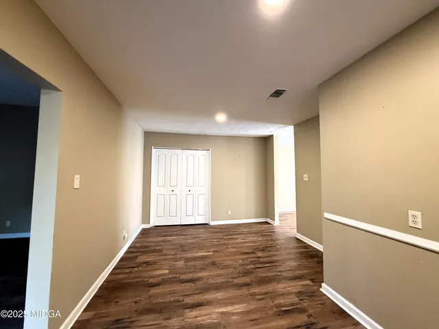 a view of empty room with wooden floor