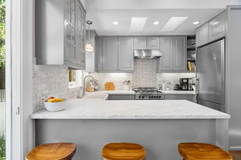 a kitchen with a sink a refrigerator and wooden floor