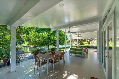 a dining room with furniture and a floor to ceiling window