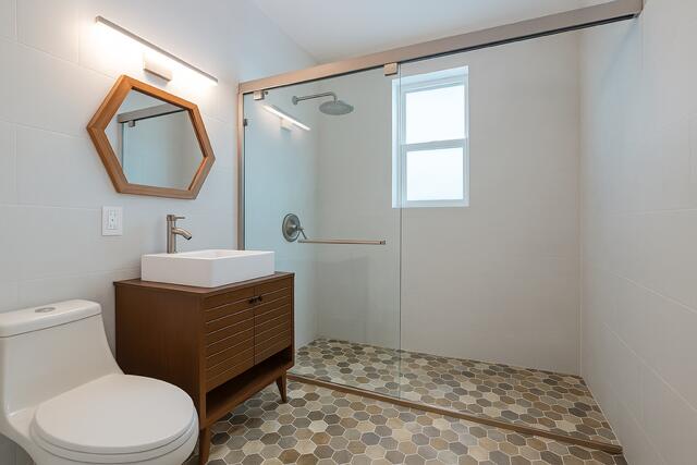 321 South Swinton Avenue Delray Beach, FL 33444 - Photo 18 of 30 a bathroom with a toilet a sink and a mirror