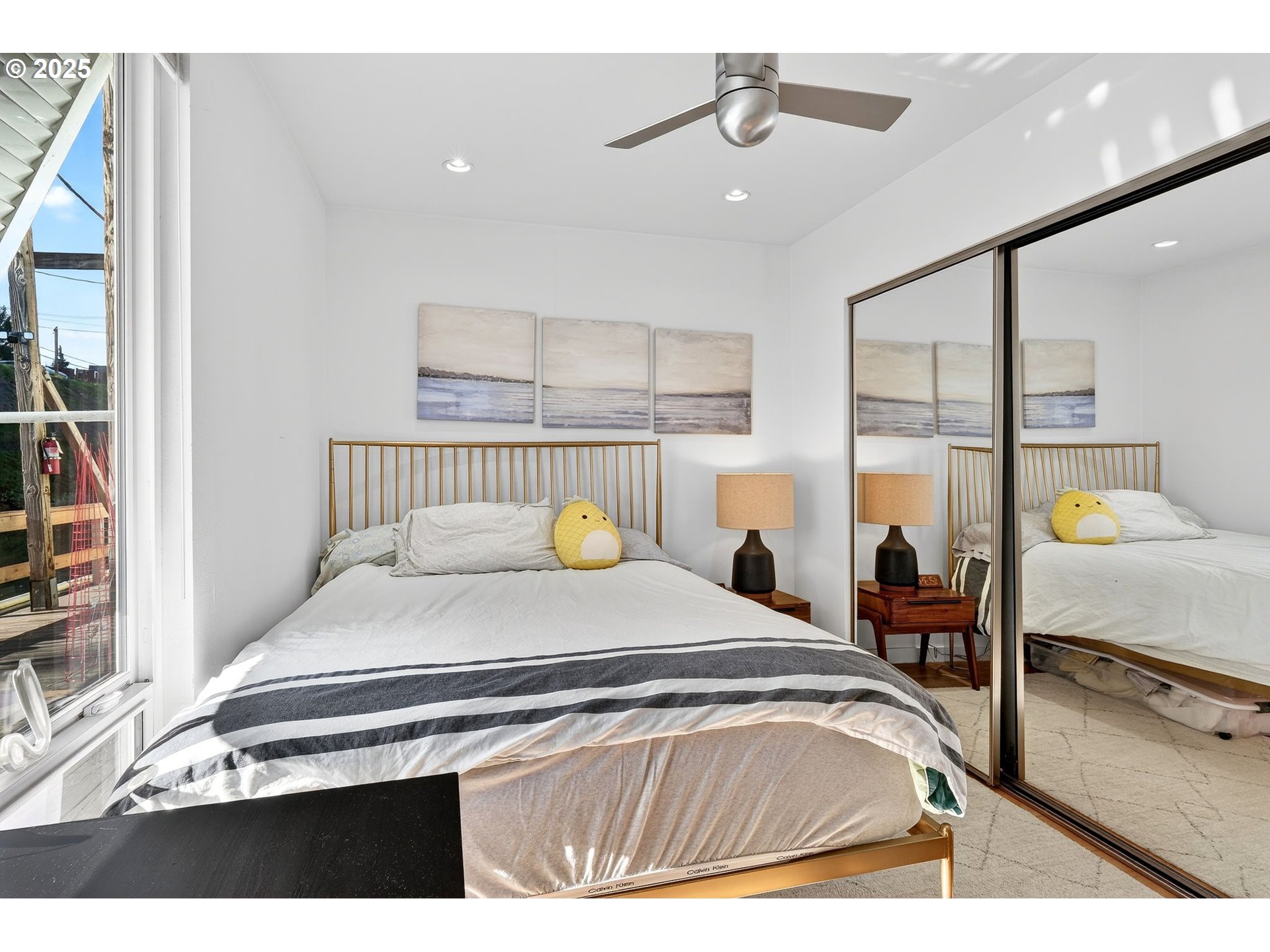 173 Northeast Bridgeton Road, Unit 13 Portland, OR 97211 - Photo 13 of 22 a bedroom with a bed and a chandelier