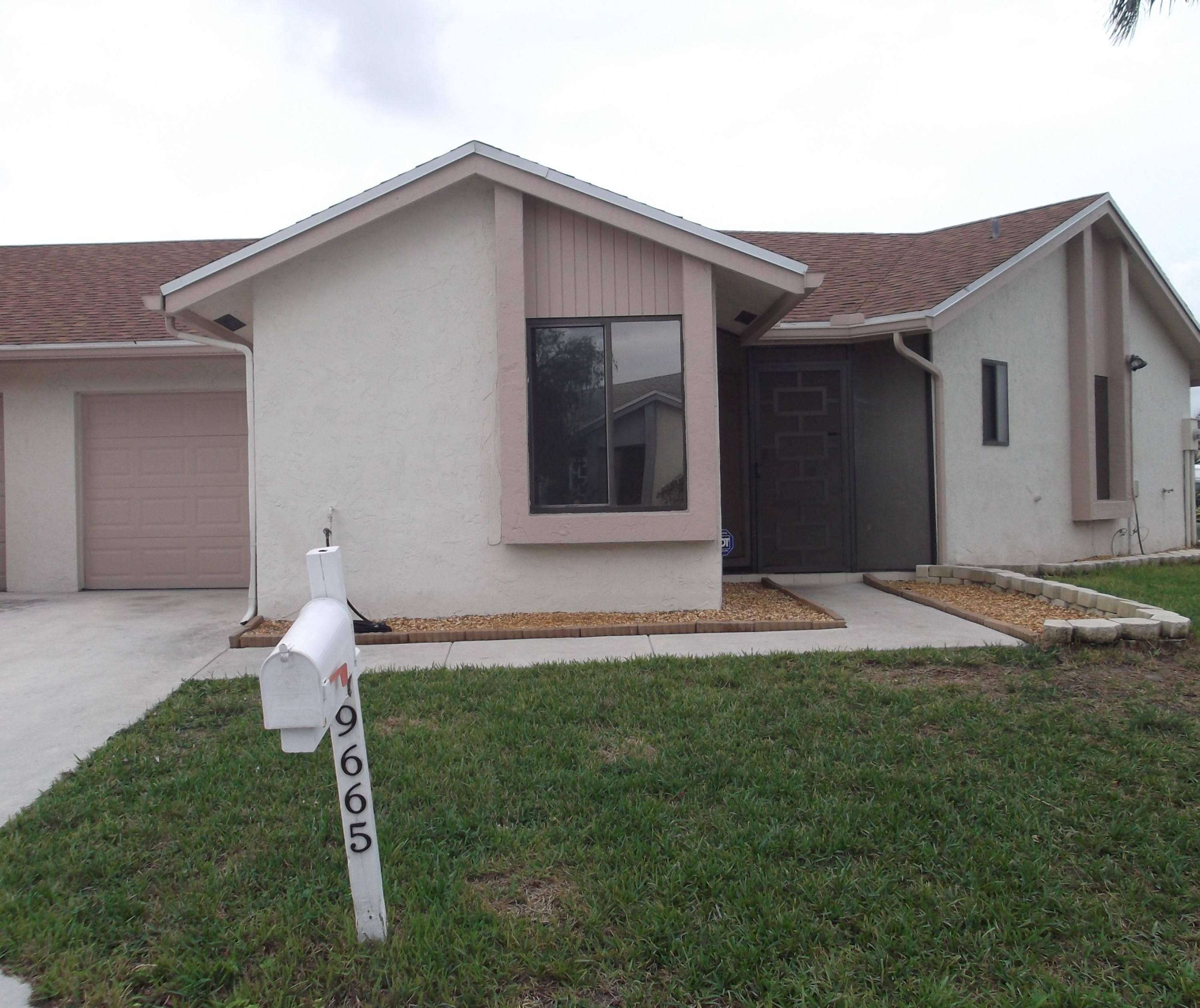 9665 Golf State Park Way Boca Raton, FL 33428 - Photo 1 of 22 a front view of a house with a yard and garage