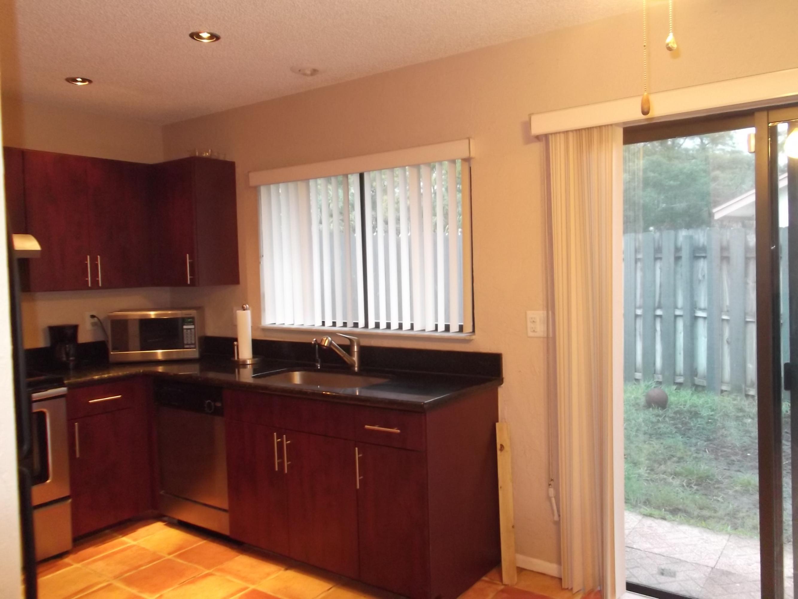 9665 Golf State Park Way Boca Raton, FL 33428 - Photo 16 of 22 a kitchen with granite countertop a sink and a window