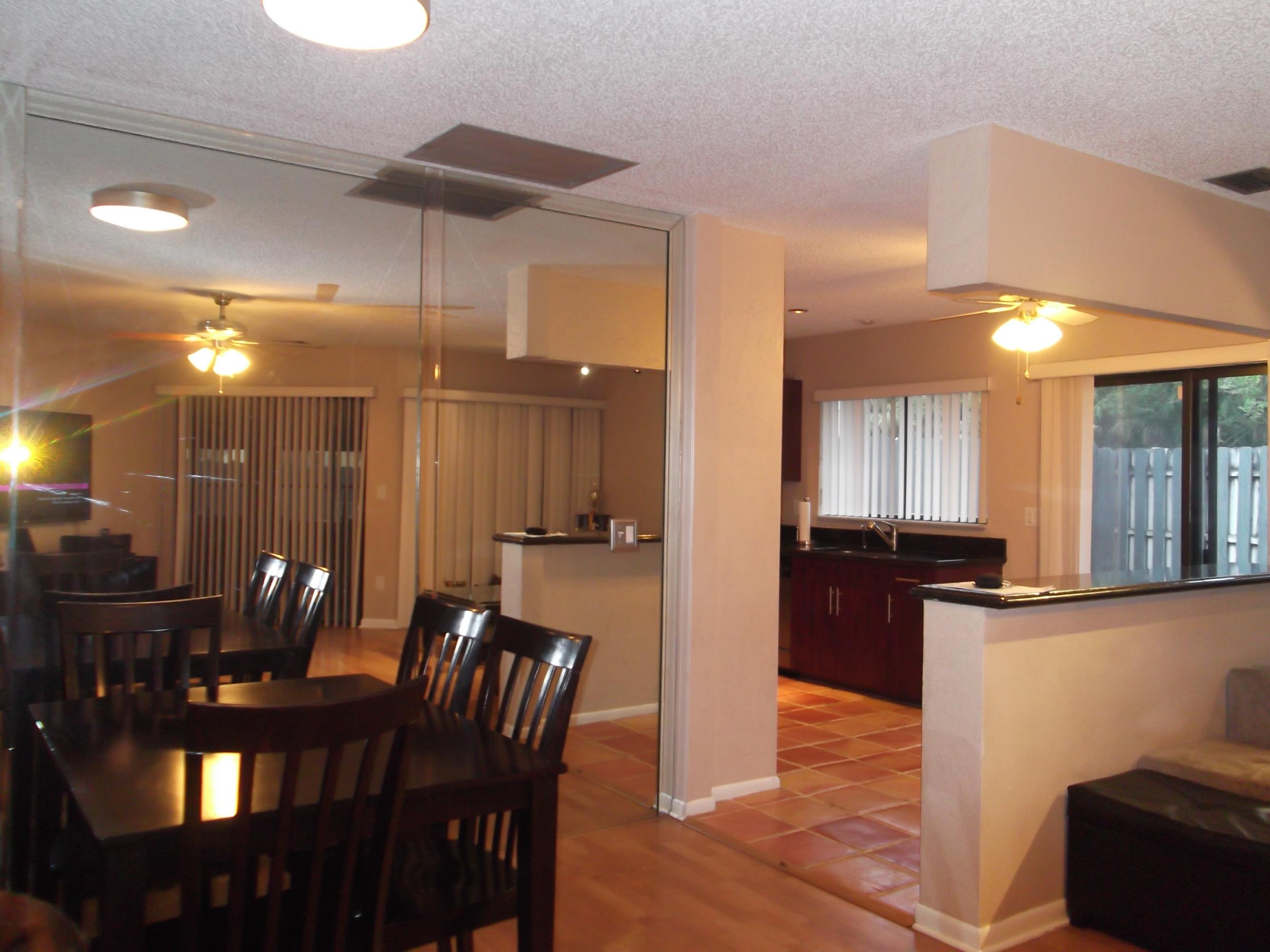 9665 Golf State Park Way Boca Raton, FL 33428 - Photo 5 of 22 a kitchen with stainless steel appliances wooden floor dining table and chairs